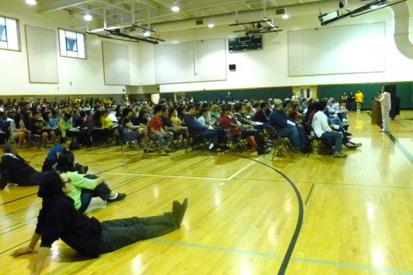 High school students and parents crowd into the gym to discuss college information. Photo by Joyce Liang. 