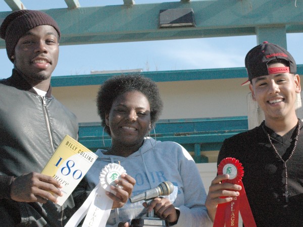 Poetry Slam winners proudly hold up their awards.