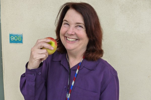 Pat Parker smiles with an apple, the symbol of education and teaching. Photo by Tyler Macias.